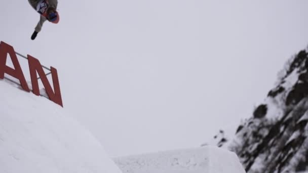 SOCHI, RUSIA - 4 DE ABRIL DE 2016: Snowboarder hace volteretas desde un trampolín. Estación de esquí. Cayendo. Truco extremo — Vídeo de stock