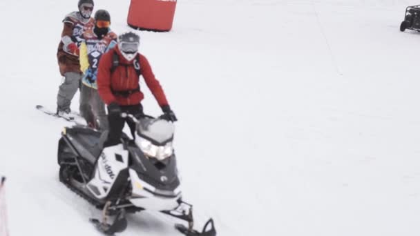 СОЧИ, РОССИЯ - 4 апреля 2016 года: Сноубордисты ездят верёвкой на снегоходе. Лыжный курорт. Склон . — стоковое видео