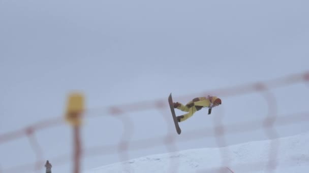 Sochi, Rusland - 4 April 2016: Snowboarder Maak volledige flip van Springplank. Skigebied. Hek. Extreme stunt — Stockvideo