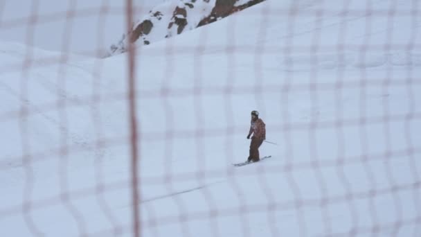 Sochi, Rusland - 4 April 2016: Skiër ritje op de helling. Skigebied. Hek. Extreme sport. Besneeuwde bergen. — Stockvideo