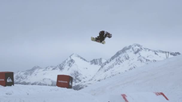 SOCHI, RUSIA - 4 DE ABRIL DE 2016: Snowboarder se da la vuelta en el salto aéreo desde el trampolín. Estación de esquí. Truco extremo — Vídeos de Stock