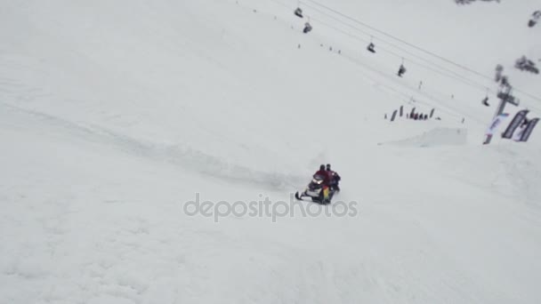 Snowboarders ride on snowmobile holding rope. Ski resort. Extreme sport. Slope — Stock Video