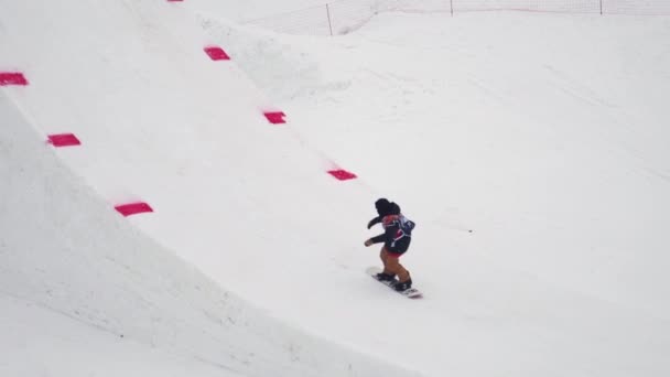 SOCHI, RUSIA - 4 DE ABRIL DE 2016: Snowboarder hacer voltear en el aire, agarrar snowboard. Estación de esquí. Paisaje de montañas — Vídeos de Stock