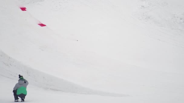 СОЧИ, РОССИЯ - 4 апреля 2016 года: Сноубордист сделать флип в воздухе, захватить доску. Лыжный курорт. Пейзаж. Экстремальный спорт — стоковое видео