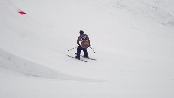 SOCHI, RUSIA - 4 DE ABRIL DE 2016: Salto de esquiador desde trampolín, cruzar los pies en el aire. Estación de esquí. Paisaje. Montañas — Vídeo de stock