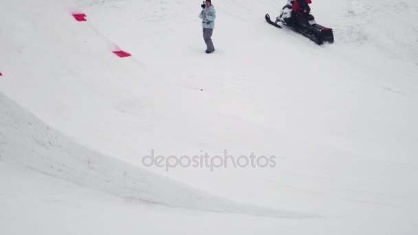 SOCHI, RUSIA - 4 DE ABRIL DE 2016: Salto snowboarder desde trampolín, voltéate en el aire. Estación de esquí. Paisaje. Nieve — Vídeo de stock