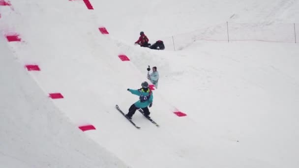 Sochi, Rusko - duben 4, 2016: Lyžař skočit z můstku, aby kousek s cross nohy ve vzduchu. Lyžařské středisko. — Stock video