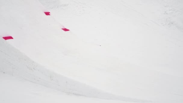 Sotschi, Russland - 4. April 2016: Snowboarder springen vom Sprungbrett, drehen sich in der Luft um. Skigebiet. — Stockvideo