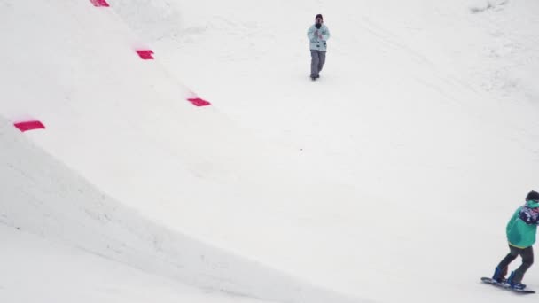 SOCHI, RUSIA - 4 DE ABRIL DE 2016: Salto snowboarder desde trampolín, hacer voltereta completa en el aire, agarrar el tablero. Cubo rojo . — Vídeos de Stock