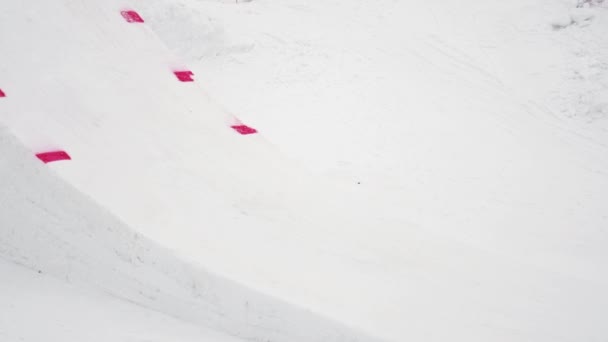 SOCHI, RUSSIA - 4 de abril de 2016: Snowboarder jump from springboard, make many full flip in air. Estância de esqui . — Vídeo de Stock
