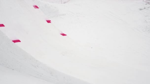 SOCHI, RUSIA - 4 DE ABRIL DE 2016: Paseo de snowboarder en trampolín, hacer voltereta completa en el aire. Estación de esquí. Cubo rojo . — Vídeo de stock