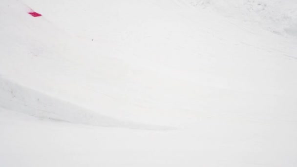 СОЧИ, РОССИЯ - 4 апреля 2016 года: прыжок лыжника с трамплина, сделать флип в воздухе. Лыжный курорт. Снегоход с всадником — стоковое видео