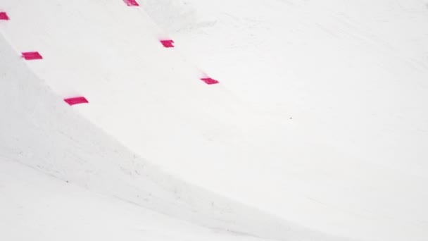SOCHI, RUSIA - 4 DE ABRIL DE 2016: El snowboarder salta desde el trampolín, da un vuelco extremo en el aire. Estación de esquí. Deporte — Vídeos de Stock