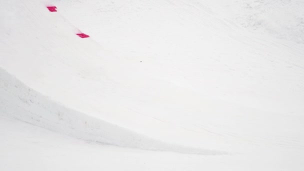 Sotschi, Russland - 4. April 2016: Snowboarder fahren auf Sprungbrett, machen Flip, berühren Board in der Luft. Skigebiet. — Stockvideo