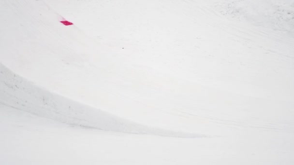 СОЧИ, РОССИЯ - 4 апреля 2016 года: Сноубордист едет на трамплине, делает поворот в воздухе. Лыжный курорт. Горы — стоковое видео