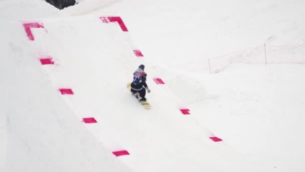 SOCHI, RUSIA - 4 DE ABRIL DE 2016: Paseo snowboarder en trampolín, hacer voltereta, tablero táctil en el aire. Gente . — Vídeos de Stock