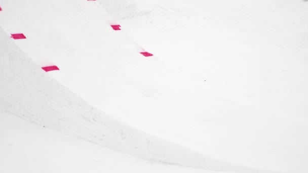 SOCHI, RUSIA - 4 DE ABRIL DE 2016: Salto snowboarder desde trampolín, hacer voltear, agarrar en el aire. Estación de esquí. Activo — Vídeo de stock
