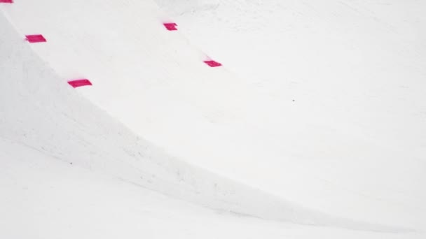 SOCHI, RUSSIA - APRIL 4, 2016: Snowboarder ride on springboard, make flip in air. Ski resort. Scenery mountains — Stock Video