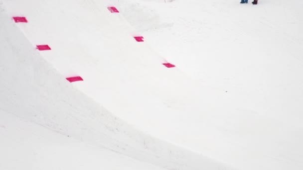 SOCHI, RÚSSIA - 4 de abril de 2016: Passeio de snowboarder no trampolim fazer salto mortal no ar. Estância de esqui. Desporto ativo — Vídeo de Stock