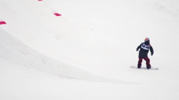 SOCHI, RUSIA - 4 DE ABRIL DE 2016: Paseo de snowboarder en trampolín, hacer voltear en el aire. Montañas nevadas. Extremo. . — Vídeos de Stock