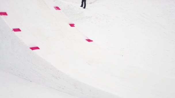 Sochi, Rusland - 4 April 2016: Snowboarder rit op Springplank, make stunts in de lucht. Besneeuwde bergen. Cameraman. — Stockvideo