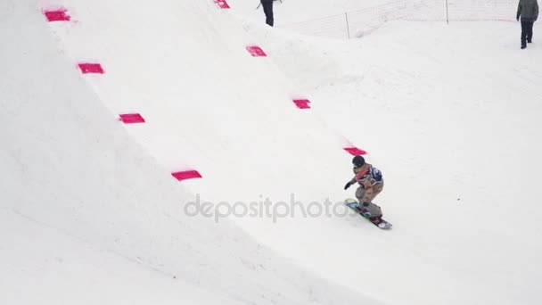 SOCHI, RUSIA - 4 DE ABRIL DE 2016: Salto snowboarder desde trampolín, hacer salto mortal. Montañas nevadas. Camarógrafo . — Vídeos de Stock