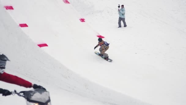 СОЧИ, РОССИЯ - 4 апреля 2016 года: Прыжок сноубордиста с трамплина, кувыркание в воздухе. Горы. Каскадер — стоковое видео