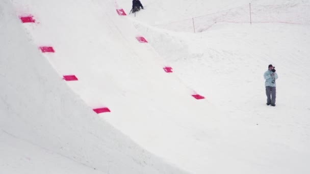 俄罗斯索契-2016 年 4 月 4 日︰ 滑雪板从跳板跳。山的景观。摄影师。一个极端 — 图库视频影像