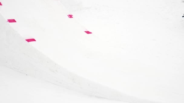 СОЧИ, РОССИЯ - 4 апреля 2016 года: Сноубордист прыгает с трамплина, делает флип в воздухе. Снежные горы. Каскадер — стоковое видео