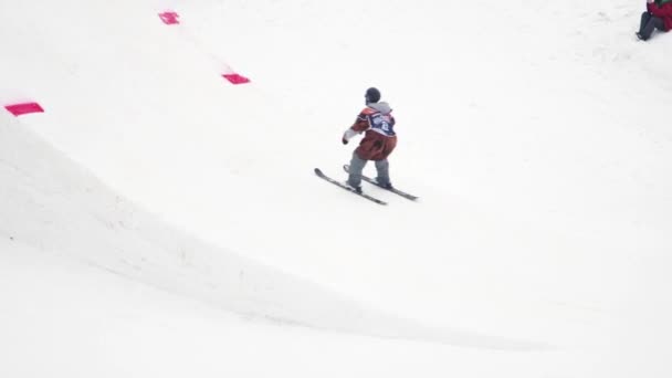 SOCHI, RUSIA - 4 DE ABRIL DE 2016: Salto de esquiador desde trampolín, pies flexibles en el aire. Montañas nevadas. Truco. Camarógrafo — Vídeo de stock