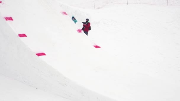 Sochi, Rusko - duben 4, 2016: Snowboard skok z odrazový můstek, aby extrémní kousek. Zasněžené hory. Kameraman — Stock video