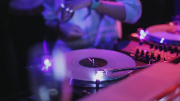 ソチ, ロシア連邦 - 2016 年 4 月 4 日: 女の子 dj ヘッドフォンのナイトクラブでパーティーにターン テーブルで回転キャップ。ライト. — ストック動画