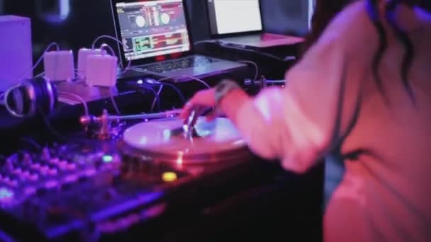 SOCHI, RUSSIA - 4 de abril de 2016: Girl dj spinning, mixagem na plataforma giratória em festa na boate. Holofotes. Dança — Vídeo de Stock