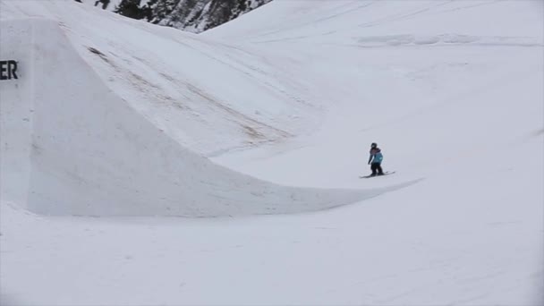 Sochi, Ryssland - April 4, 2016: Skidåkare hoppa från springboard. Skidorten. Grått väder. Skylt med röd bokstav — Stockvideo