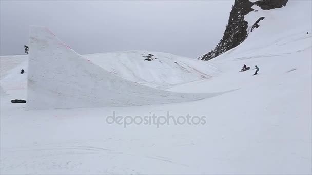 Sochi, Rusland - 4 April 2016: Skiër sprong van de Springplank, maken spiegelen. Besneeuwde bergen. Skigebied. Cameraman. — Stockvideo