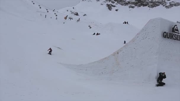 Σότσι, Ρωσία - 4 Απριλίου 2016: Snowboarder άλμα από ψηλά την αφετηρία, κάνουν ακροβατικά στον αέρα. Χιονοδρομικό κέντρο. Βουνό — Αρχείο Βίντεο