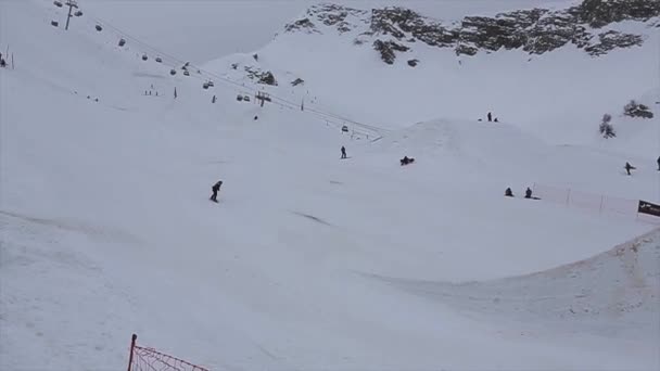 SOCHI, RUSSIE - 4 AVRIL 2016 : Le snowboardeur saute du tremplin haut, faire flip. Station de ski. Encamp. Le sport — Video