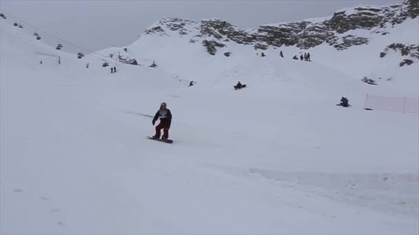 SOCHI, RUSIA - 4 DE ABRIL DE 2016: Salto snowboarder desde trampolín alto, hacer voltereta. Montañas. Camarógrafo . — Vídeo de stock