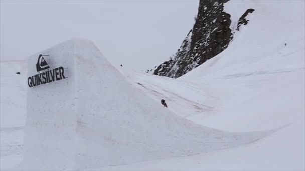 Sochi, Ryssland - April 4, 2016: Skidåkare hoppa från höga springboard, göra extrema flip. Skidorten. Snöig. Rött kub — Stockvideo