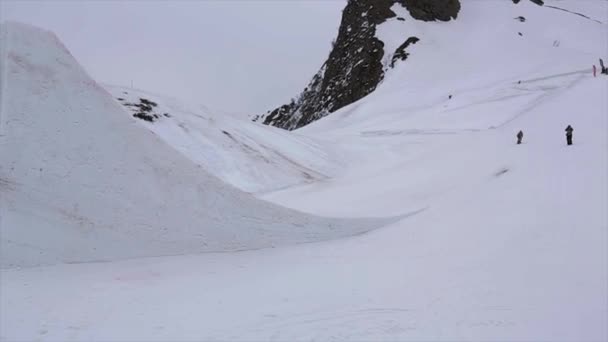 Sochi, Rusko - duben 4, 2016: Snowboardista skok z odrazový můstek, aby extrémní dvojité Salto. Lyžařské středisko. — Stock video