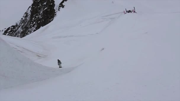 SOCHI, RUSIA - 4 DE ABRIL DE 2016: Salto de esquiador desde trampolín alto en la estación de esquí. Montañas nevadas. Hacer trucos — Vídeos de Stock