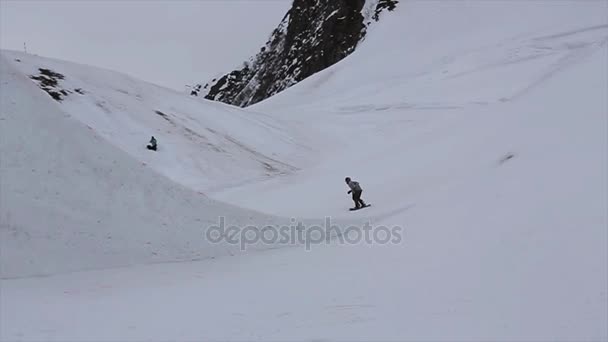 СОЧИ, РОССИЯ - 4 апреля 2016 года: Поездка на сноуборде на высоком трамплине на горнолыжном курорте. Горы. Сделай сальто. Спорт — стоковое видео