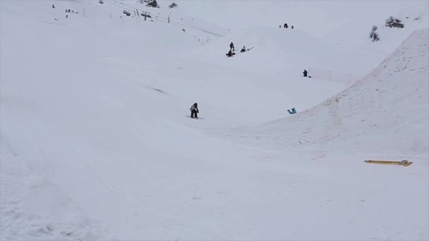 Sochi, Rusland - 4 April 2016: Skiër sprong van hoge Springplank in skigebied. Draai in de lucht. Besneeuwde berg — Stockvideo