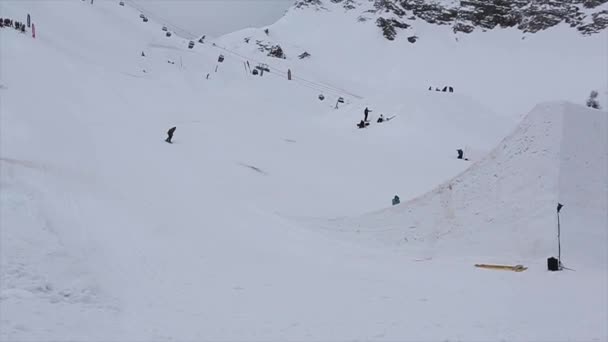 Sochi, Ryssland - April 4, 2016: Snowboardåkare hopp från hög språngbräda på skidorten. Stunts. Bergen. Personer — Stockvideo