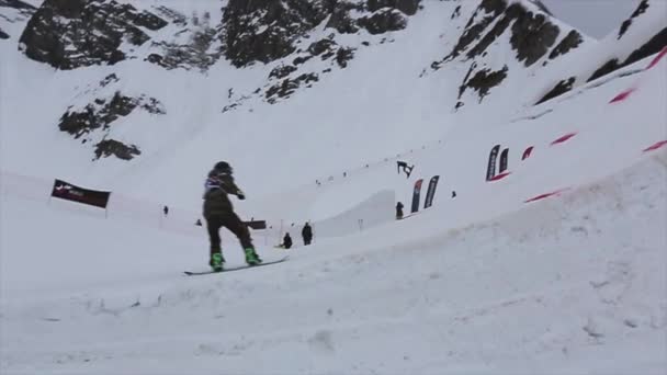 СОЧИ, РОССИЯ - 4 апреля 2016 года: прыжок сноубордиста с трамплина на горнолыжном курорте. Горы. Делать трюки — стоковое видео