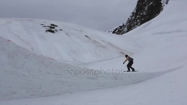 Sochi, Rusko - duben 4, 2016: Snowboardista skok od odrazový můstek na lyžařské středisko. Hory. Učinit, drapák, překlopit — Stock video