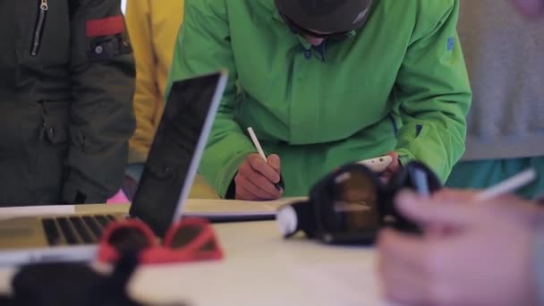 Sochi, Rusland - 4 April 2016: Man in ski uniform maken handtekening in encamp op ski-oord. Sportevenement. Mensen — Stockvideo