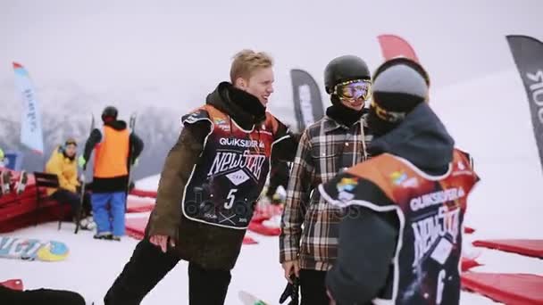 SOCHI, RUSIA - 4 DE ABRIL DE 2016: Los snowboarders se calientan antes del concurso en la estación de esquí. Haciendo ejercicios. Deporte — Vídeos de Stock