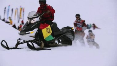 Sochi, Rusya Federasyonu - 4 Nisan 2016: Snowboard ve kayakçı ipi tutan Karmobil binmek. Kayak Merkezi. Spor.