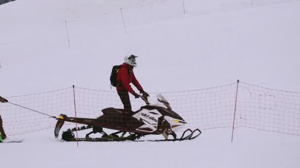 Σότσι, Ρωσία - 4 Απριλίου 2016: Snowboarder βόλτα με snowmobile κρατώντας στο σχοινί. Χιονοδρομικό κέντρο. Βουνά. Αθλητισμός. — Αρχείο Βίντεο